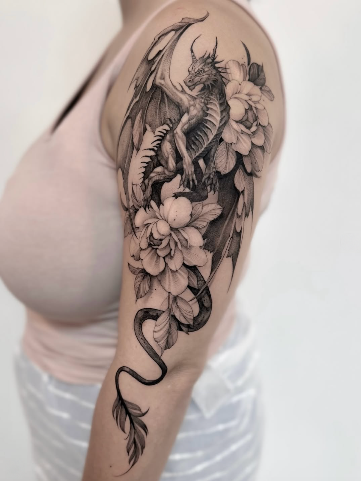 Drache und florale Linien · Oberarm · Tattoo von Annlie, Velvet Line Karlsruhe