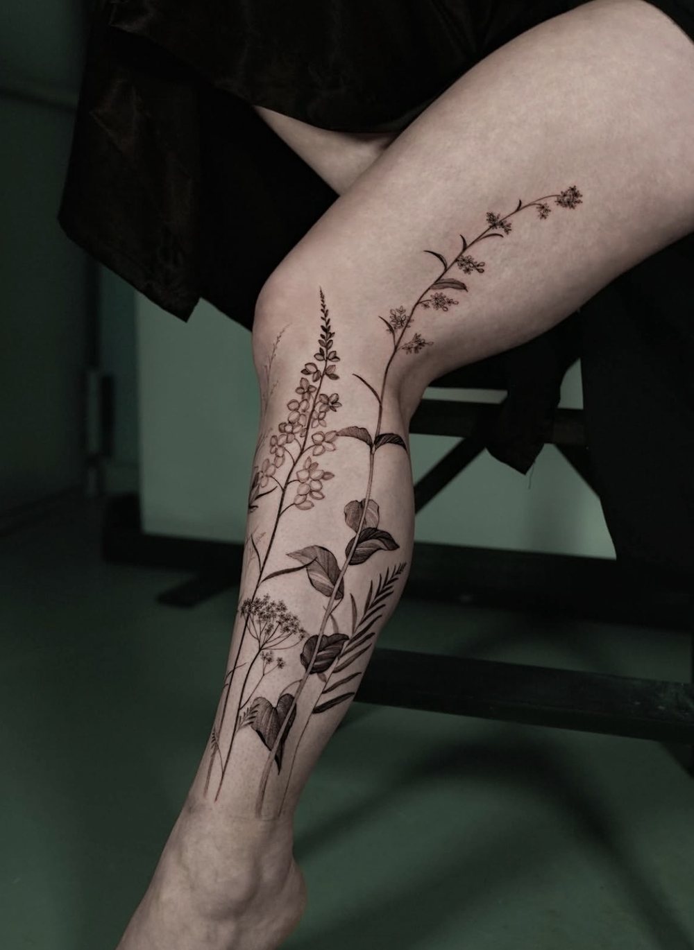 Feine Wildblumen und Gräser als Fine Line Tattoo am Bein, von Misha, Velvet Line Karlsruhe