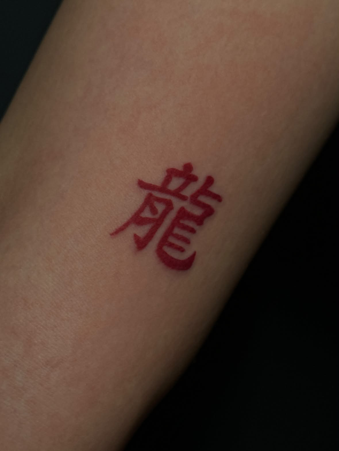 Schriftzeichen „Drache“ in Rot · Farbe und Schrift · Unterarm · Tattoo von Inna, Velvet Line Karlsruhe