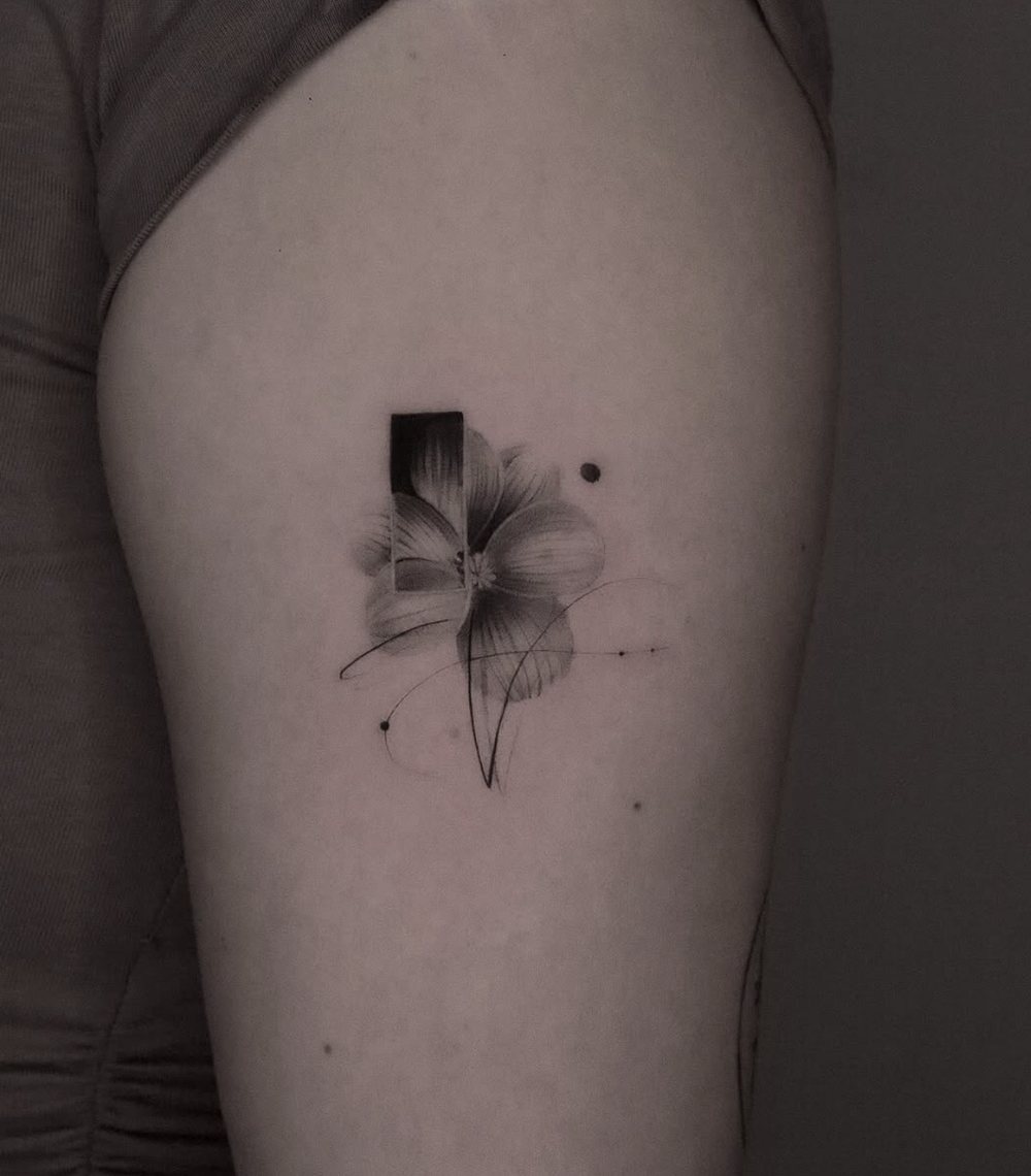 Blüte mit grafischen Linien, Fine Line Tattoo am Oberarm, von Barni, Velvet Line Karlsruhe
