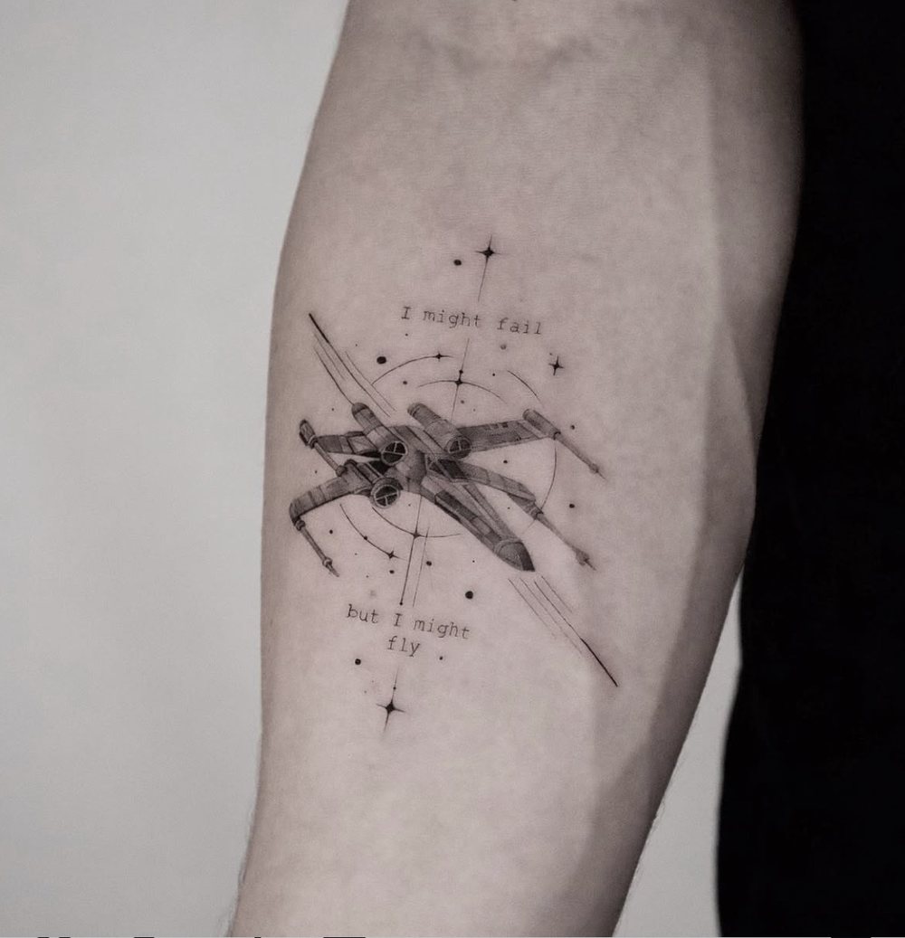 Raumschiff mit Schriftzug, illustratives Micro Realistic Tattoo am Oberarm, von Barni, Velvet Line Karlsruhe